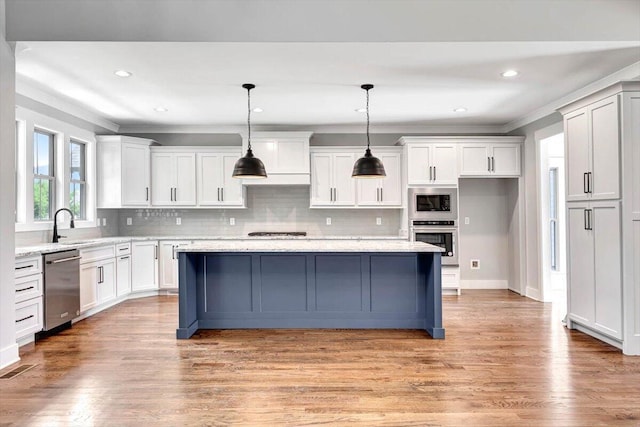 kitchen with light wood-style floors, appliances with stainless steel finishes, and white cabinets