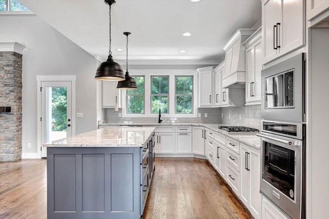 kitchen with oven, gas cooktop, backsplash, and light wood-style flooring