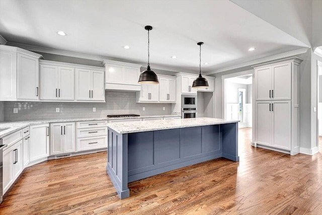 kitchen featuring built in microwave, white cabinets, crown molding, and light wood-style floors