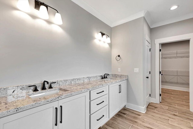 full bath featuring a sink, baseboards, wood finished floors, and ornamental molding