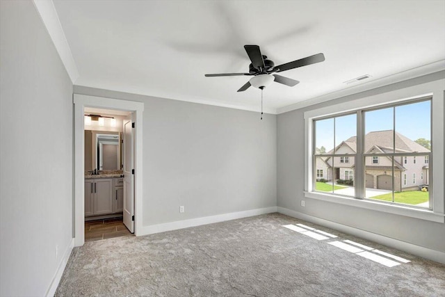 unfurnished bedroom with visible vents, ensuite bathroom, carpet, crown molding, and baseboards