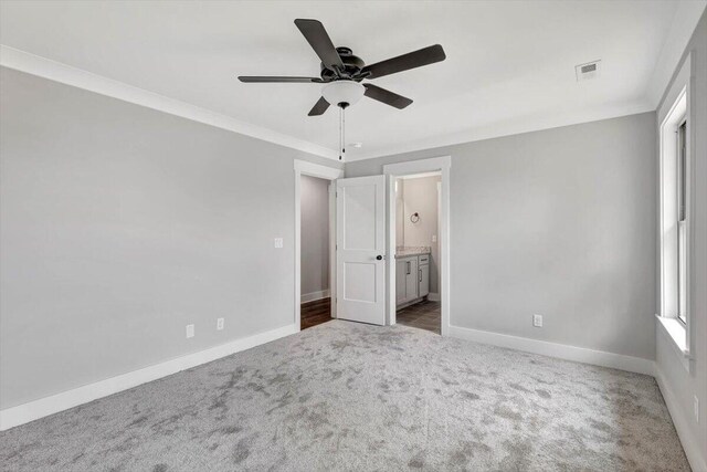 unfurnished bedroom with visible vents, baseboards, carpet, and crown molding