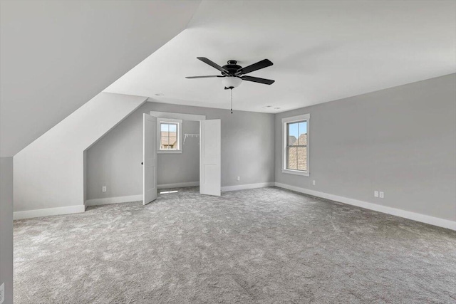 additional living space featuring baseboards, carpet, lofted ceiling, and ceiling fan