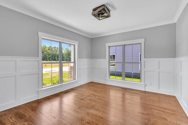 empty room with wood-type flooring and crown molding