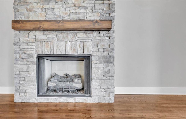 details featuring a fireplace, baseboards, and wood finished floors