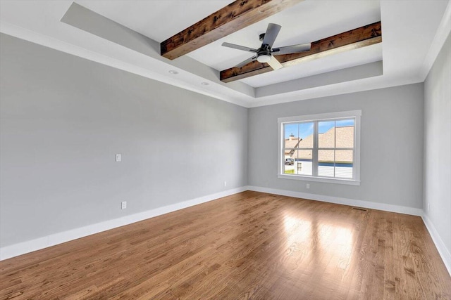 spare room with a raised ceiling, beam ceiling, ceiling fan, and light hardwood / wood-style floors