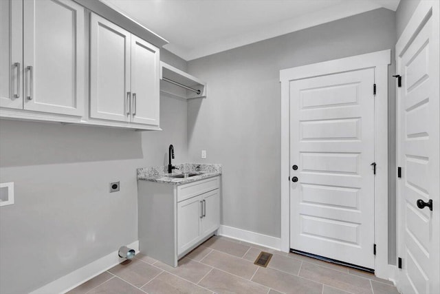 laundry area featuring light tile patterned floors, hookup for an electric dryer, cabinets, and sink