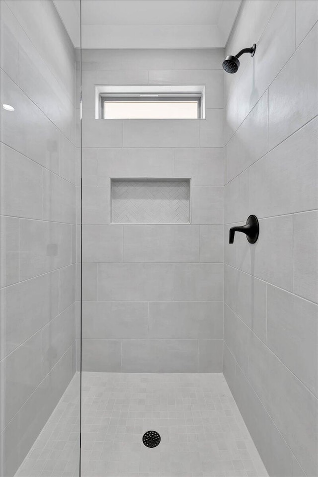 bathroom featuring tiled shower and plenty of natural light