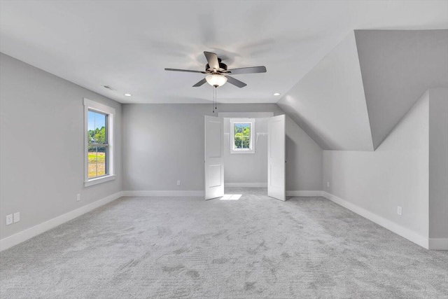 bonus room with ceiling fan, light colored carpet, and plenty of natural light