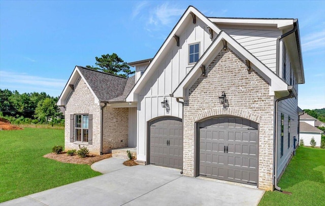 view of front of home with a front yard, driveway, an attached garage, brick siding, and board and batten siding