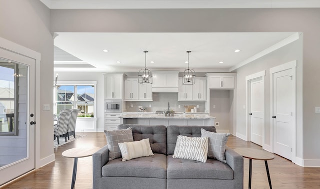 living room featuring crown molding, hardwood / wood-style floors, and plenty of natural light