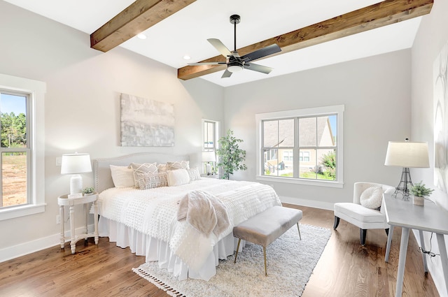 bedroom with beamed ceiling, baseboards, wood finished floors, and a ceiling fan