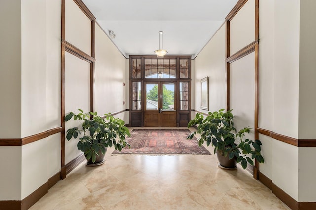 entrance foyer featuring baseboards and french doors