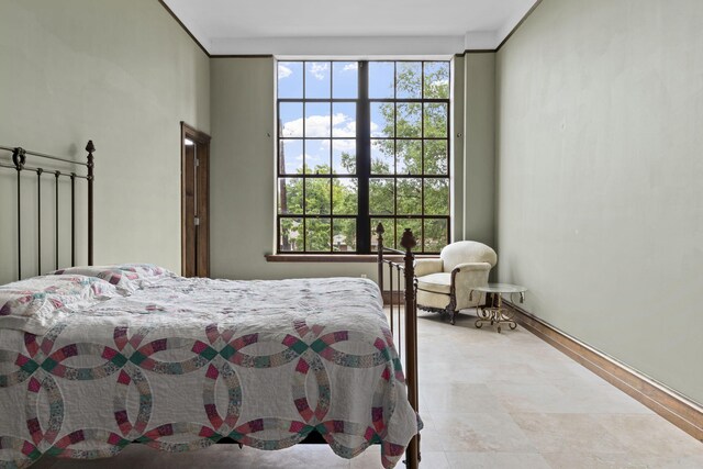 bedroom with floor to ceiling windows and light tile patterned floors