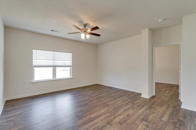 spare room featuring a textured ceiling, dark wood-type flooring, and ceiling fan