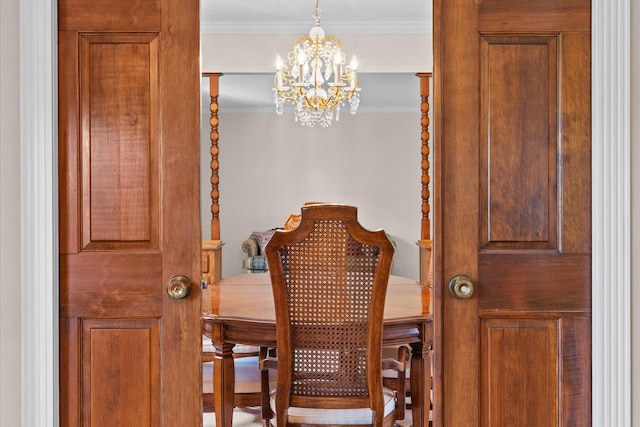 dining room with ornamental molding and a notable chandelier