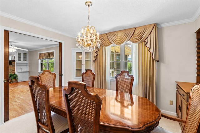 dining area with light wood-type flooring, ceiling fan with notable chandelier, a textured ceiling, and ornamental molding