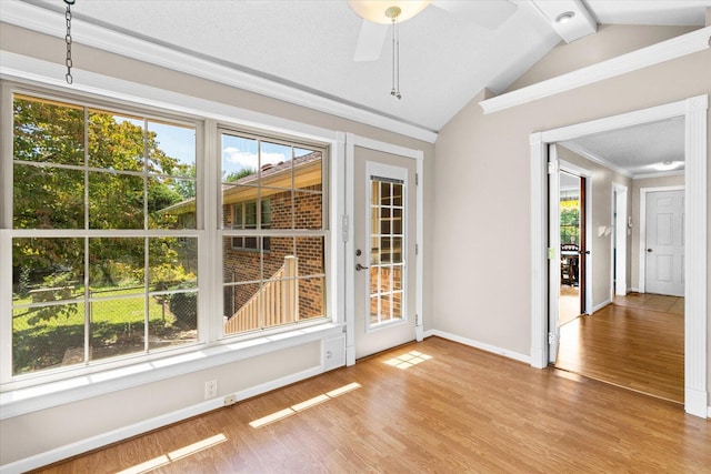 spare room with lofted ceiling, ceiling fan, ornamental molding, and wood-type flooring