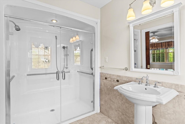 bathroom featuring tile walls, an enclosed shower, ceiling fan, and tile patterned flooring