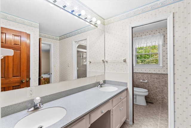 bathroom featuring vanity, walk in shower, tile patterned flooring, tile walls, and toilet