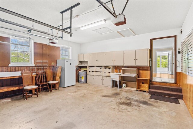 garage featuring a garage door opener and wooden walls