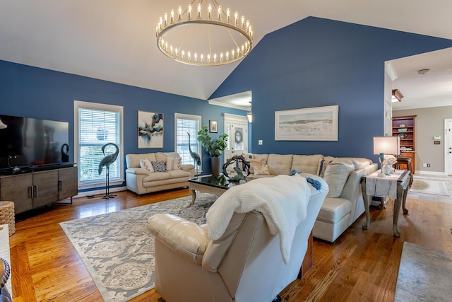 living room with an inviting chandelier, lofted ceiling, and hardwood / wood-style flooring