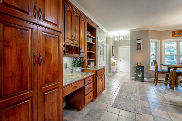 kitchen with light stone countertops, ornamental molding, light tile patterned floors, decorative light fixtures, and an inviting chandelier