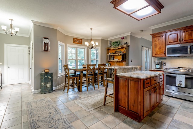 kitchen featuring stainless steel appliances, crown molding, pendant lighting, an inviting chandelier, and a center island