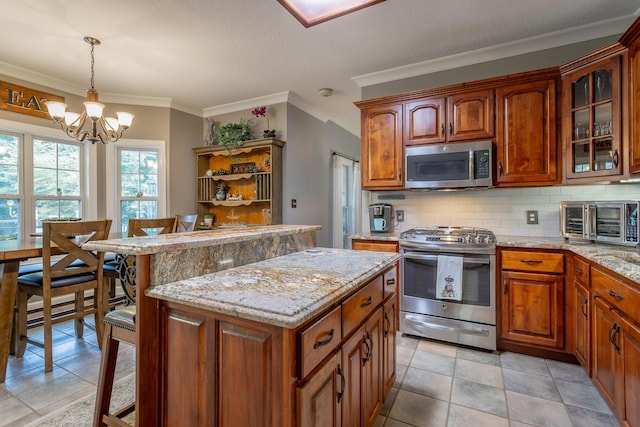 kitchen with a kitchen breakfast bar, stainless steel appliances, hanging light fixtures, and an inviting chandelier