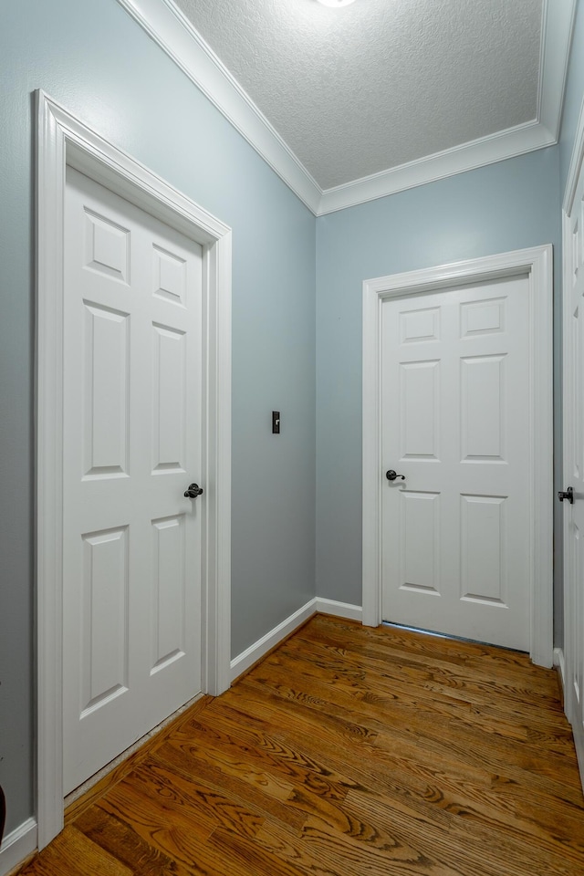 entryway with dark hardwood / wood-style flooring, ornamental molding, and a textured ceiling