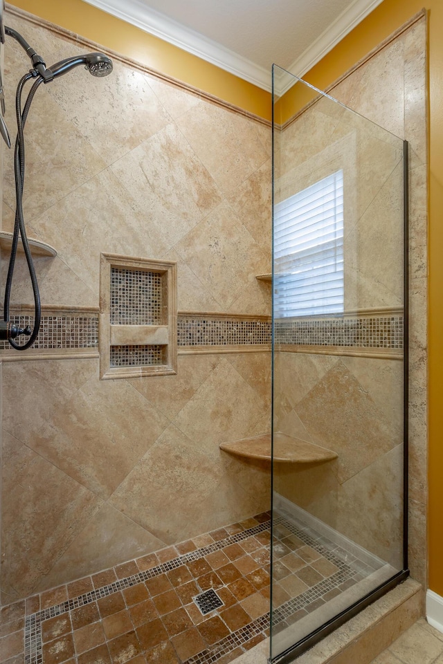 bathroom with tiled shower and crown molding