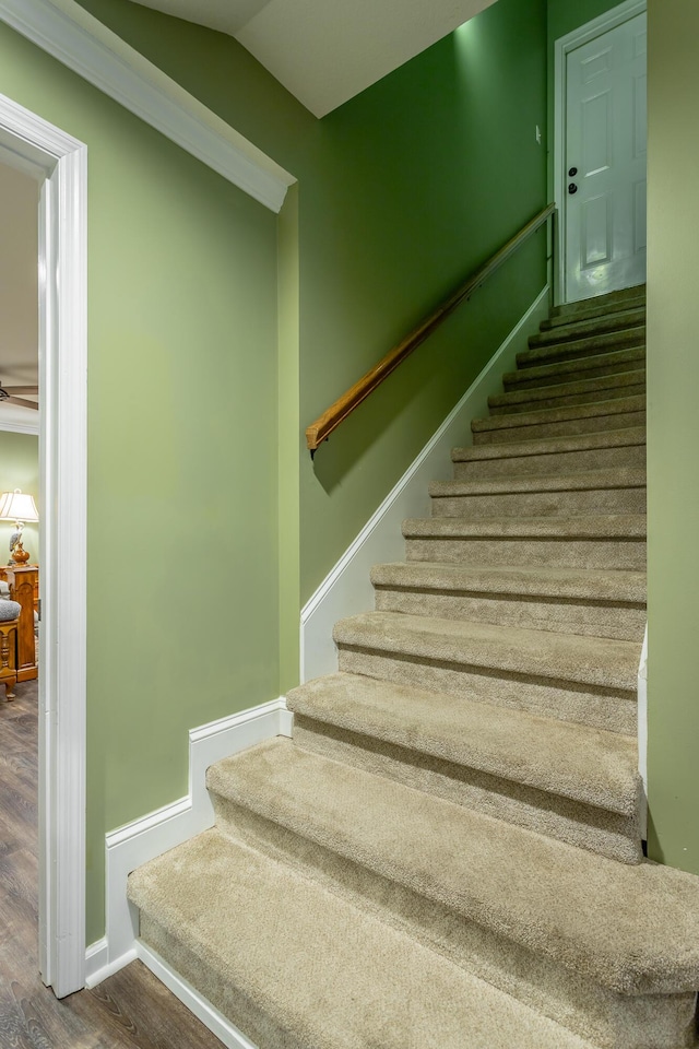 staircase with hardwood / wood-style floors, ceiling fan, and ornamental molding