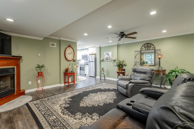 living room featuring ceiling fan, ornamental molding, and hardwood / wood-style flooring