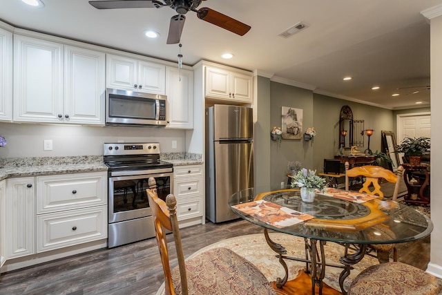 kitchen featuring light stone counters, white cabinetry, dark wood-type flooring, and appliances with stainless steel finishes