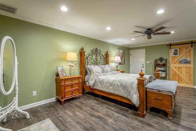 bedroom with a barn door, ceiling fan, dark hardwood / wood-style floors, and ornamental molding