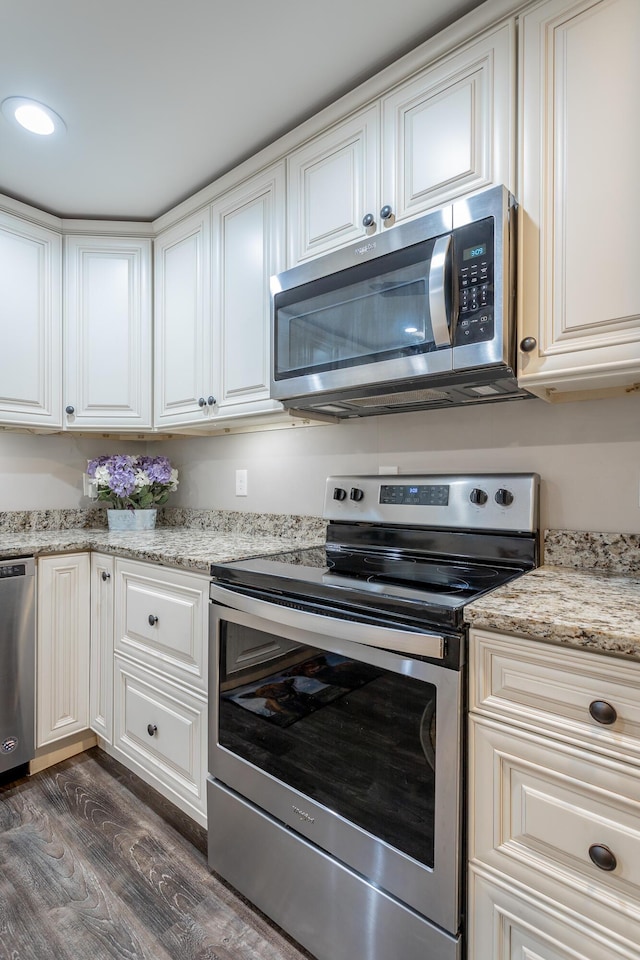 kitchen featuring light stone counters, white cabinets, dark hardwood / wood-style floors, and appliances with stainless steel finishes