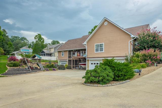 view of front facade with a playground and a garage