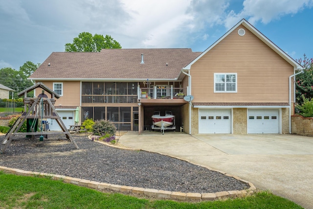 rear view of property featuring a sunroom and a garage