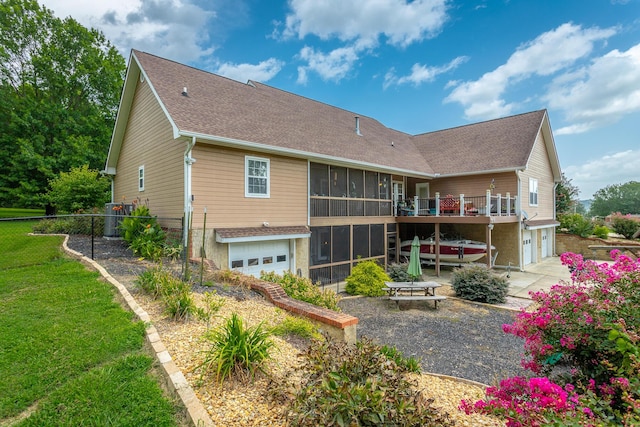 back of property featuring a patio area, a sunroom, and a garage