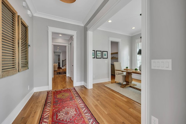 hall featuring ornamental molding and light hardwood / wood-style flooring