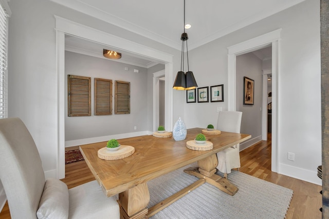 dining room featuring crown molding and light hardwood / wood-style floors