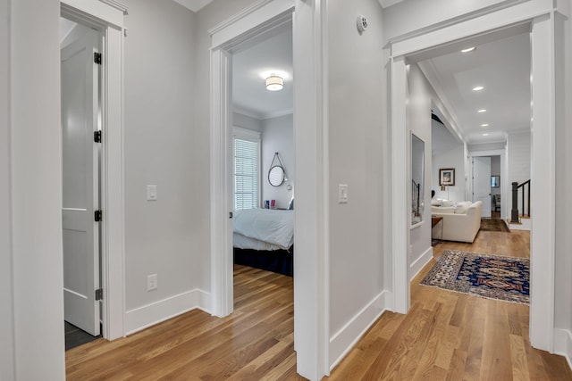 corridor featuring crown molding and light hardwood / wood-style floors