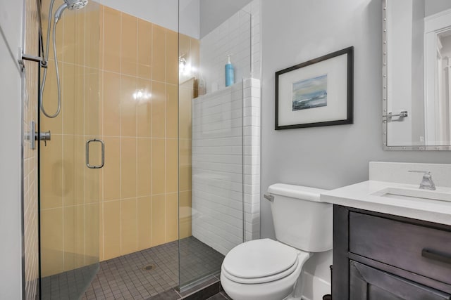 bathroom with toilet, an enclosed shower, and vanity