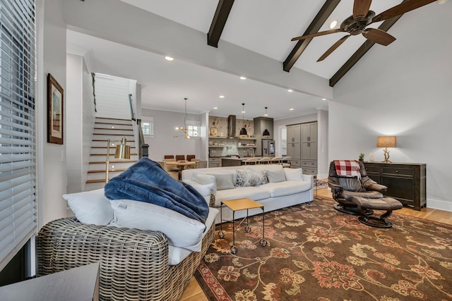 living room featuring ceiling fan, wood-type flooring, and vaulted ceiling with beams