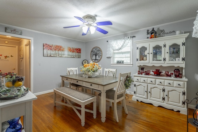 dining space with crown molding, a textured ceiling, hardwood / wood-style flooring, and ceiling fan