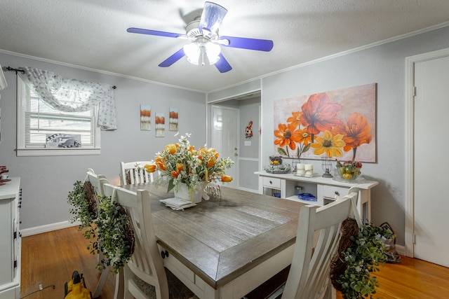 dining room with a textured ceiling, ceiling fan, ornamental molding, and light wood-type flooring