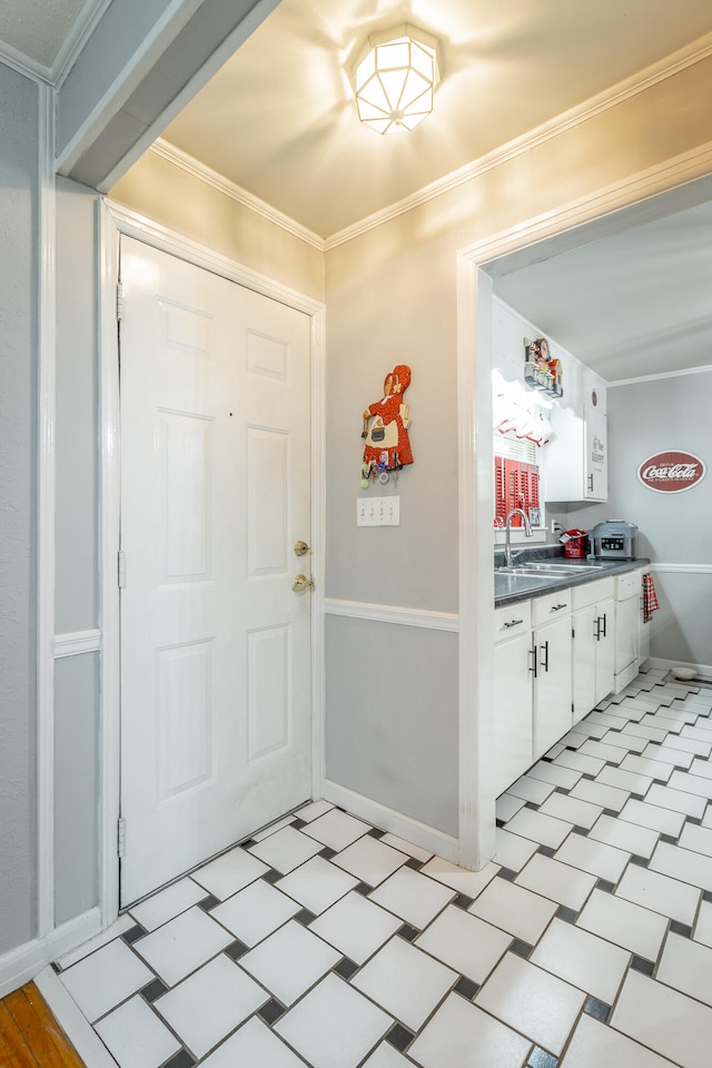 entryway featuring ornamental molding and sink