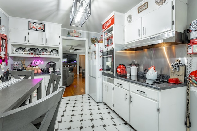 kitchen with ceiling fan, ornamental molding, white fridge, and white cabinetry