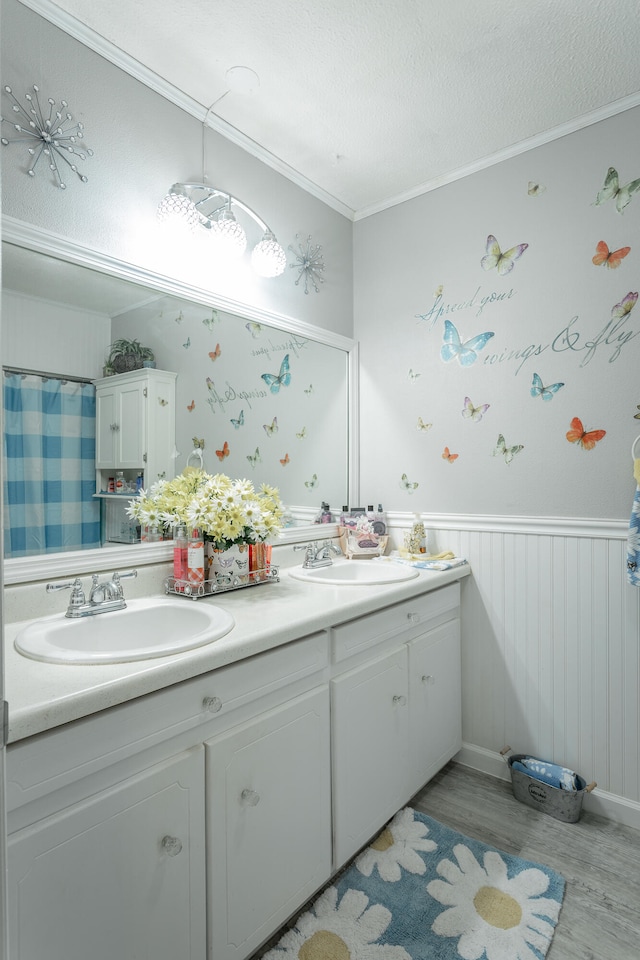 bathroom featuring a textured ceiling, vanity, ornamental molding, and wood-type flooring