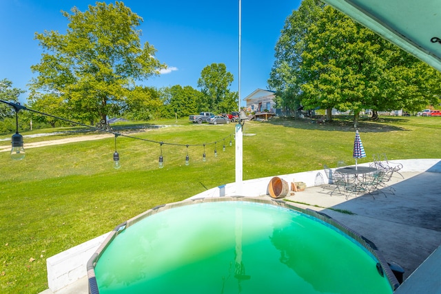 view of pool featuring a lawn and a patio